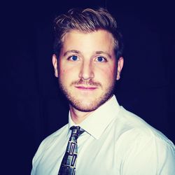 Portrait of young man against black background