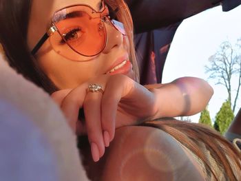 Close-up of young woman wearing sunglasses while lying in tent