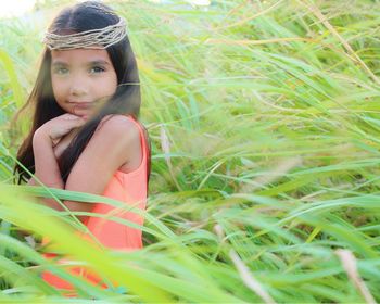 Portrait of cute girl wearing threads on head amidst plants