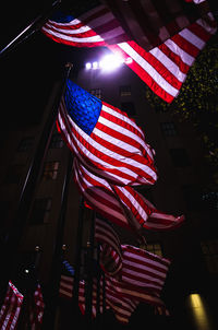 Low angle view of flags on illuminated city at night