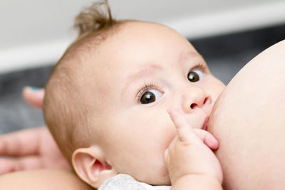 Close-up portrait of baby being breastfed