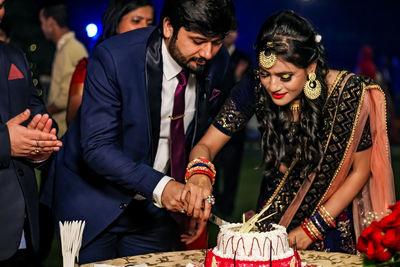 A couple is cutting cake on their engagement ceremony 