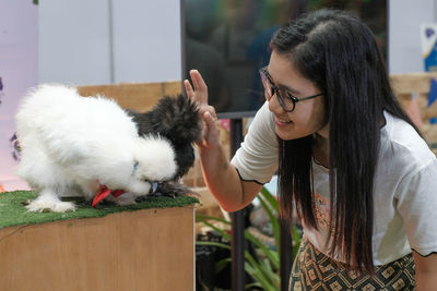 Smiling young woman looking at rabbit