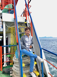 Man sitting in boat against sea