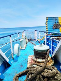 Boat moored on shore against blue sky