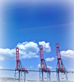 Low angle view of crane against cloudy sky