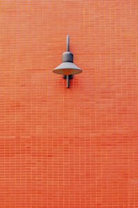 Low angle view of lamp on brick wall