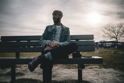 Full length of young man sitting on bench