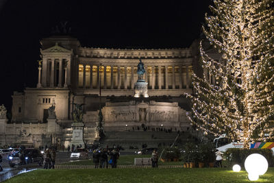 Statue in illuminated city at night