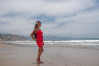 Full length of woman standing on beach against sky