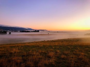 Scenic view of land against sky during sunset