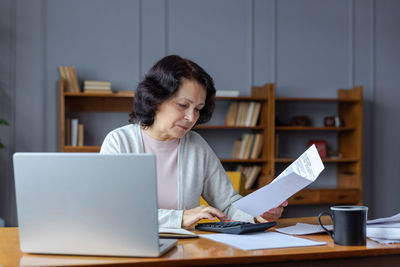 Young woman using laptop at table