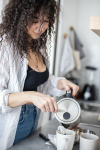 Woman preparing coffee at home