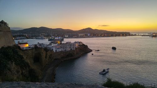 High angle view of sea by city against clear sky