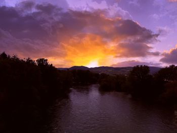 Scenic view of river against sky during sunset