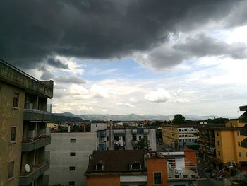 Buildings against cloudy sky