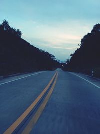 Empty road along trees