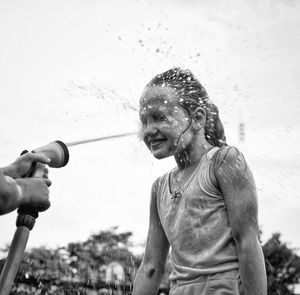 Children are doused with water from a hose