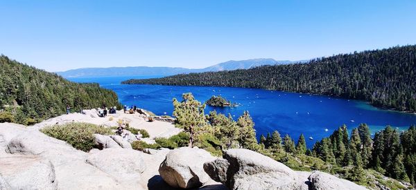 Scenic view of lake and mountains against clear blue sky