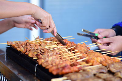 Midsection of person preparing food on barbecue grill