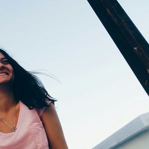 Cropped image of smiling woman against sky