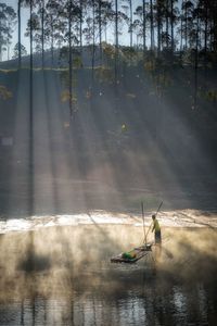 Rear view of people kayaking in lake