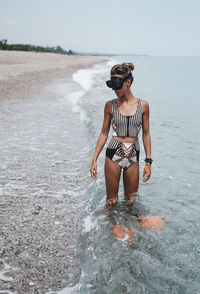 Full length of young woman standing in water