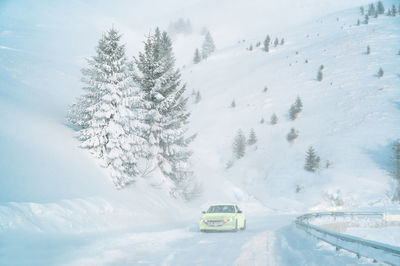 Car on snowy mountain road during winter blizzard