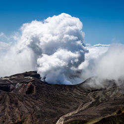 Smoke emitting from volcanic mountain against sky