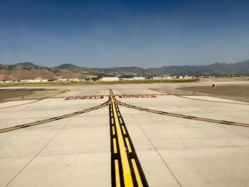 Airplane on airport runway against clear sky