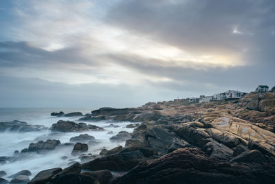 Scenic view of rocks on beach against sky