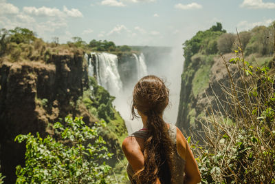 Rear view of woman looking at waterfall