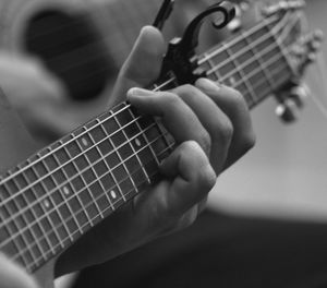 Cropped hands playing guitar
