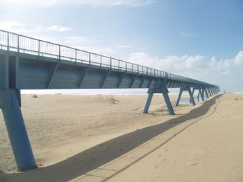 View of bridge on beach against sky