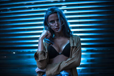 Young woman standing by window at night