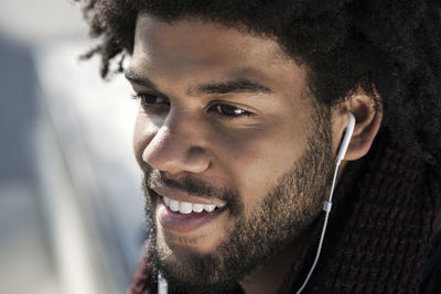 Portrait of smiling man listening to music on his earphones