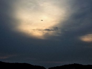 Low angle view of silhouette birds flying against sky