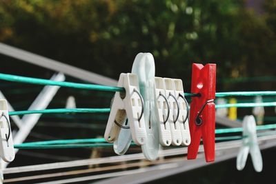 Close-up of clothespins hanging on fence