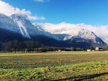 Scenic view of field and mountains against sky