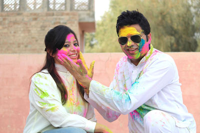 Portrait of smiling mid adult couple playing holi