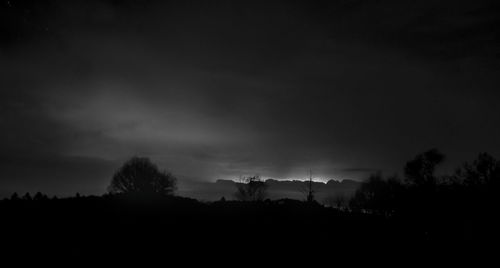 Silhouette trees on landscape against sky