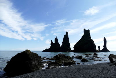 Rocks on beach against sky