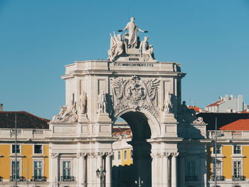 Low angle view of statue in city against clear sky