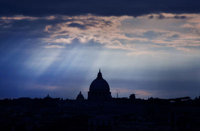 Silhouette of building against cloudy sky