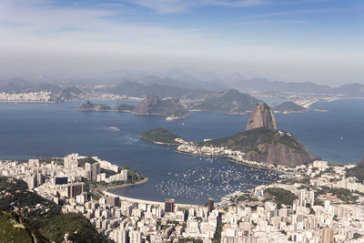 High angle view of townscape by sea against sky