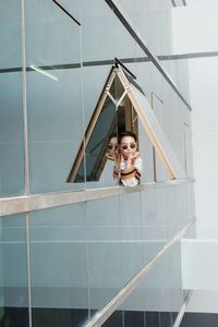 Portrait of woman looking through window