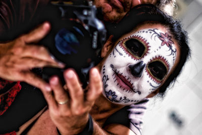 Portrait of woman wearing spooky make-up while photographing at home