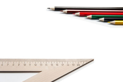High angle view of pencils on table against white background
