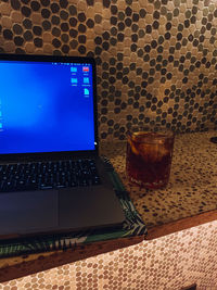 Low angle view of wine glass on table against wall