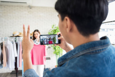 Side view of young woman using mobile phone while sitting at home